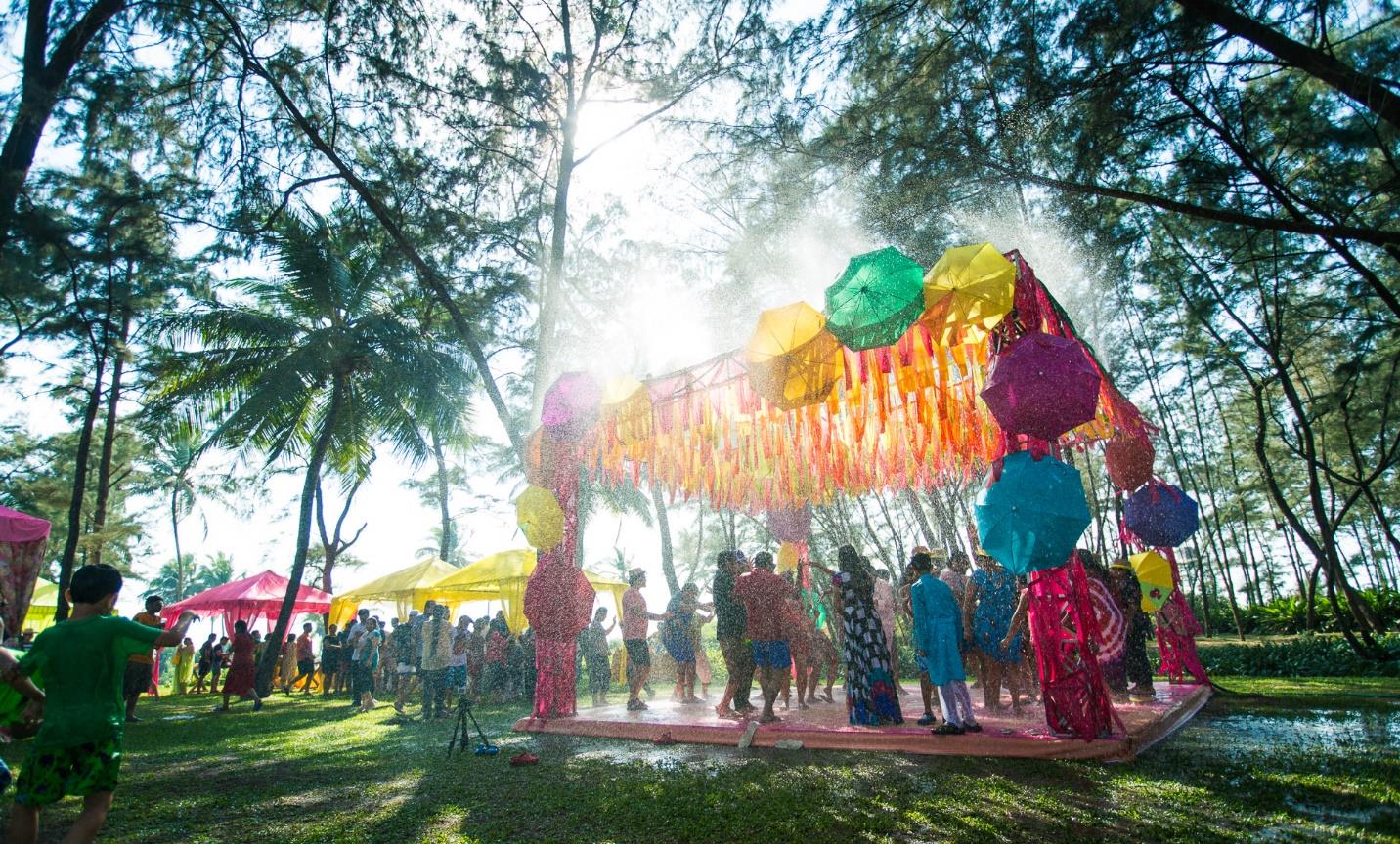 Guests celebrating under umbrellas at a daytime pre-wedding function